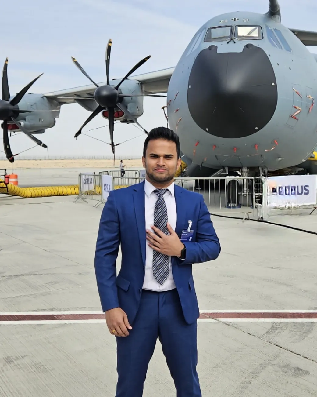 Abhith Rajan in a blue suit, standing in front of an Airbus A400M at the Dubai Airshow